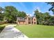 Elegant brick home with a sprawling front yard, a long driveway, and mature trees at 3711 Mountain Cove Rd, Snellville, GA 30039