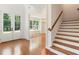 Bright foyer with staircase, wood floors, and a view into the living room with chandelier at 3711 Mountain Cove Rd, Snellville, GA 30039