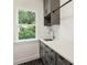 Bright laundry room features a sink, cabinetry, and a window overlooking the backyard at 3711 Mountain Cove Rd, Snellville, GA 30039
