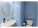 Powder room features a pedestal sink, an oval mirror, and blue walls at 5420 Stevehaven Ln, Cumming, GA 30028