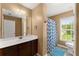 Well-lit bathroom with a single sink vanity, patterned shower curtain, and a window at 5420 Stevehaven Ln, Cumming, GA 30028
