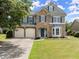 Charming two-story home featuring a stone facade, two-car garage, manicured lawn, and classic curb appeal at 5420 Stevehaven Ln, Cumming, GA 30028