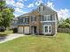 Charming two-story home featuring a stone facade, two-car garage, manicured lawn, and classic curb appeal at 5420 Stevehaven Ln, Cumming, GA 30028
