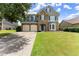 Charming two-story home featuring a stone facade, two-car garage, manicured lawn, and classic curb appeal at 5420 Stevehaven Ln, Cumming, GA 30028