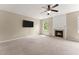 Cozy living room with neutral carpet, a ceiling fan, a wall-mounted TV, and a fireplace at 5420 Stevehaven Ln, Cumming, GA 30028