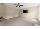 Large living room features neutral carpet, a ceiling fan, and a wall-mounted television at 5420 Stevehaven Ln, Cumming, GA 30028