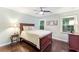 Primary bedroom with hardwood floors, neutral bedding, and dual windows offering natural light at 6630 Club Valley Ct, Suwanee, GA 30024