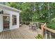 Outdoor deck featuring a table and chairs, with views of mature trees and a landscaped yard at 6630 Club Valley Ct, Suwanee, GA 30024