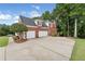 Traditional brick home with a three-car garage and paved driveway nestled among mature trees at 6630 Club Valley Ct, Suwanee, GA 30024
