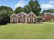 Charming brick home boasts a well-manicured lawn and mature trees, enhancing its curb appeal at 6630 Club Valley Ct, Suwanee, GA 30024