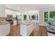 Modern kitchen featuring white cabinets, stainless steel appliances, a granite island, and an adjacent breakfast nook with bright windows at 6630 Club Valley Ct, Suwanee, GA 30024