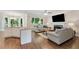 Open-concept living area with fireplace, hardwood floors, and adjacent kitchen island at 6630 Club Valley Ct, Suwanee, GA 30024