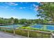 A view of tennis courts with beautiful blue courts and mature trees, offering a scenic playing experience at 6630 Club Valley Ct, Suwanee, GA 30024
