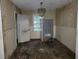 Empty dining room space with hardwood floors, neutral walls, trim detailing, and a vintage hanging light fixture at 1159 Eastridge Sw Rd, Atlanta, GA 30311