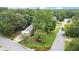 Aerial view of a well-maintained home with mature trees, a lush lawn, and a brick driveway at 1418 Mill Path Loop, Lawrenceville, GA 30045