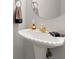 Bathroom featuring a pedestal sink with gold-tone fixtures and a round mirror at 1418 Mill Path Loop, Lawrenceville, GA 30045