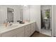Bright white bathroom featuring double sinks, elegant vanity, and a separate toilet room at 1418 Mill Path Loop, Lawrenceville, GA 30045