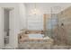 Elegant bathroom with a soaking tub, tiled shower, and chandelier at 1418 Mill Path Loop, Lawrenceville, GA 30045