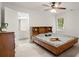 Bright bedroom boasts a wooden platform bed, with an ensuite bathroom, and a ceiling fan at 1418 Mill Path Loop, Lawrenceville, GA 30045