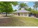 Community clubhouse surrounded by a green lawn and mature trees at 1418 Mill Path Loop, Lawrenceville, GA 30045