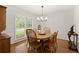 A cozy dining room with a round table, wood chairs, and natural light from the window at 1418 Mill Path Loop, Lawrenceville, GA 30045