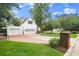 View of the 3 car garage with brick driveway and lush green lawn at 1418 Mill Path Loop, Lawrenceville, GA 30045