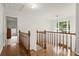 Upstairs hallway with wood railing and floors leading to bedrooms at 1418 Mill Path Loop, Lawrenceville, GA 30045