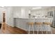 Kitchen view with bar seating and stainless appliances, leading to hardwood floors at 1418 Mill Path Loop, Lawrenceville, GA 30045