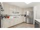 Bright kitchen featuring stainless steel appliances, white cabinets, and tile flooring at 1418 Mill Path Loop, Lawrenceville, GA 30045