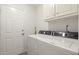 Laundry room with modern washer and dryer, next to a white door at 1418 Mill Path Loop, Lawrenceville, GA 30045