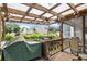 Relaxing porch with transparent pergola, featuring a grill and seating for outdoor entertainment at 1418 Mill Path Loop, Lawrenceville, GA 30045