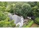 A rear exterior view of a home with a screened porch, patio, and lush greenery at 1418 Mill Path Loop, Lawrenceville, GA 30045