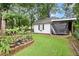 View of white shed exterior with black trim and a garden area, perfect for storage and hobbies at 1418 Mill Path Loop, Lawrenceville, GA 30045