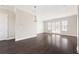 Large living area with hardwood flooring, a modern pendant light, white walls, and access to the patio at 164 Blakemore Dr, Smyrna, GA 30080