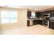 An open concept kitchen features tile flooring, dark cabinets and granite countertops at 620 River Mist Dr, Jonesboro, GA 30238