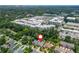 An aerial view showcases a neighborhood near commercial buildings and retail spaces, surrounded by lush trees at 1282 Kendrick Ne Rd, Brookhaven, GA 30319