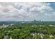 Aerial shot featuring a city skyline viewed behind a lush green expanse filled with trees and residential buildings at 1282 Kendrick Ne Rd, Brookhaven, GA 30319
