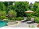 The backyard has a lovely pool with a tanning ledge, lounge chairs, patio and beautiful landscaping at 1282 Kendrick Ne Rd, Brookhaven, GA 30319