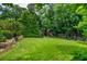 Large grassy backyard features a playset, mature trees, lovely landscaping and plenty of space for outdoor activities at 1282 Kendrick Ne Rd, Brookhaven, GA 30319