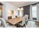 Bright dining room with a wooden table, decor, area rug, modern chandelier and two large windows at 1282 Kendrick Ne Rd, Brookhaven, GA 30319