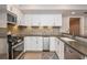 Modern kitchen with stainless steel appliances, white cabinets, and a brick backsplash at 1282 Kendrick Ne Rd, Brookhaven, GA 30319