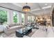 Open-concept living room with fireplace, hardwood floors, large windows, and view into the kitchen and staircase at 1282 Kendrick Ne Rd, Brookhaven, GA 30319