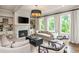 Inviting living room with a fireplace, built-in shelves, hardwood floors, and large windows overlooking green space at 1282 Kendrick Ne Rd, Brookhaven, GA 30319
