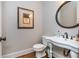Elegant powder room featuring a pedestal sink, round mirror and decorative artwork at 1282 Kendrick Ne Rd, Brookhaven, GA 30319