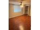 This bedroom features laminate floors, ceiling fan, large window, and a closet at 5581 Marbut Rd, Lithonia, GA 30058