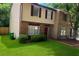 Two-story townhouse with red brick and siding, complemented by a lush green lawn at 5581 Marbut Rd, Lithonia, GA 30058