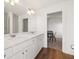 Bathroom featuring dual sinks, white cabinetry, and a view into another room at 1313 Pj East Rd, Covington, GA 30014