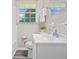 Bright bathroom featuring a clean white sink, toilet, mirror, and a window for natural light at 190 Judy Sw Ln, Atlanta, GA 30315