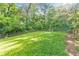 Grassy backyard enclosed by a wooden fence with lush trees in the distance at 222 Bishop Ne Dr, Marietta, GA 30060