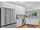 Kitchen featuring stainless steel refrigerator, white cabinets, and open layout to living room at 2263 Nottley Dr # 2, Marietta, GA 30066